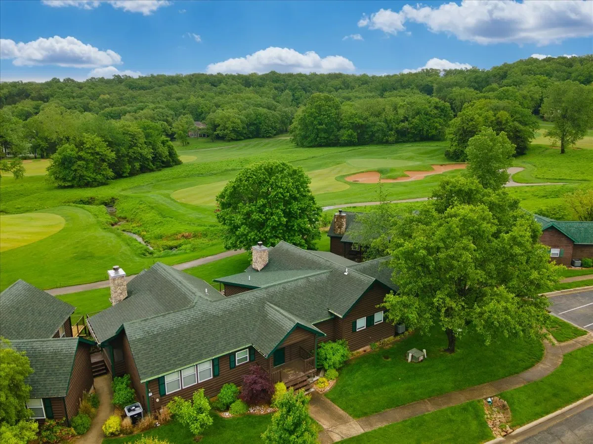 Expansive green landscape with a golf course framed by wooden houses and lush trees. The tranquil setting is ideal for leisurely walks, scenic views, and quiet moments together, highlighting the proximity to natural beauty and the panoramic vistas mentioned in the section.