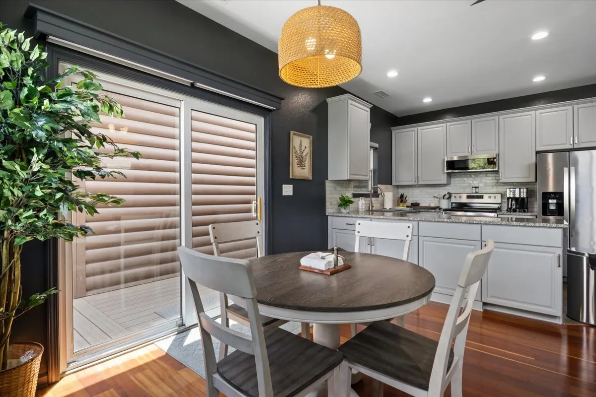 This image centers on the dining table, kitchen counter, sliding glass door, and a pendant light, capturing both dining and casual seating options. The warm, welcoming mood underscores the idea of gathering for family meals, holiday celebrations, or morning coffee, making it ideal for the eat-in kitchen & dining retreat narrative.